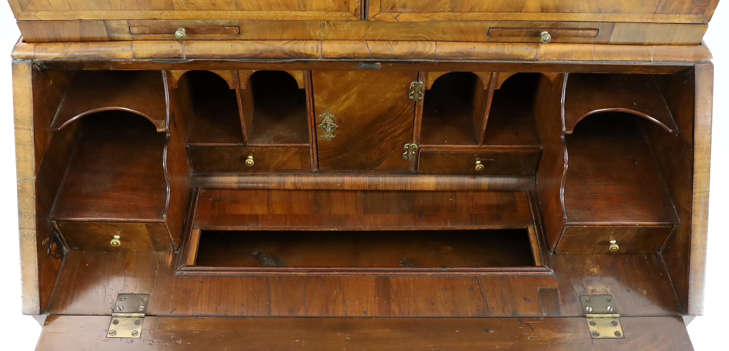 An early 18th century feather banded walnut bureau bookcase, width 96cm depth 57cm height 198cm